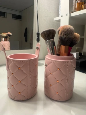 Rosa fodral till sminkborstar -  Rosa fodral med gulddetaljer. 