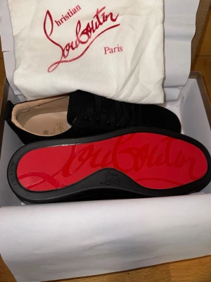 Svarta sneakers från Christian Louboutin - Säljer just nu detta feta par Louboutin skor i strl 45 passar även 44. Helt oanvända. Allt på bilderna medföljer. Vid frågor är de bara att skriva!