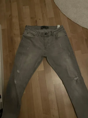 Grå slim jeans med slitningar från y2 - Helt nya säljer eftersom de är försmå nypris 1000 säljer för 430 kan gå ner vid snabb affär