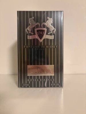 Parfums de Marly Layton EdP 125ml - Säljes efter som jag vill tjäna lite pengar, endast använd som ”trofé” pga allergi.                             Lyxig parfym från Parfums de Marly, modellen Layton Royal Essence. Flaskan rymmer 125 ml och kommer i en elegant svart förpackning med silverdetaljer och hästmotiv. Doften är Eau de Parfum och utstrålar exklusivitet och klassisk parisisk stil.