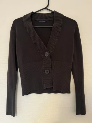 Mörkbrun kofta ullblandning - Mörkbrun kofta, bra skick, kofta är gjort av 10% ull och 90% bomull, men har inget problem med att tvättas normalt i 40. Hittar ingen storlek men skulle säga XS/S