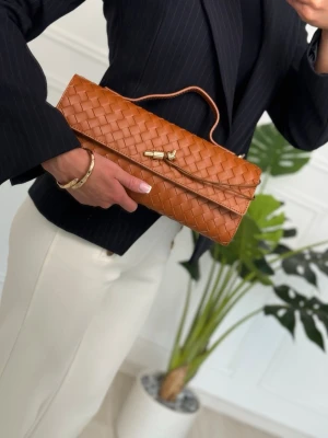 Crafted from premium 100% genuine Italian leather 🇮🇹 - Snygg brun kuvertväska i flätat skinn med elegant handtag och guldfärgad detalj framtill. Väskan har en avlång form och passar perfekt när du vill addera lite extra stil till din outfit. Enkel men trendig design som sticker ut.