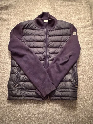 Mörkblå teddyjacka från Moncler - Snygg mörkblå teddyjacka från Moncler med quiltad front och stickade ärmar. Jackan har dragkedja framtill, två sidofickor med dragkedja och Moncler-logga på ärmen. För ett jätte bra pris, priset kan diskuteras vid snabb affär, kom dm vid frågor✅