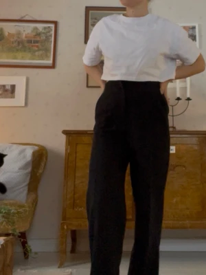 Svarta högmidjade raka kostymbyxor  - Snygga svarta högmidjade kostymbyxor med rak passform. Klassisk design med veck. 