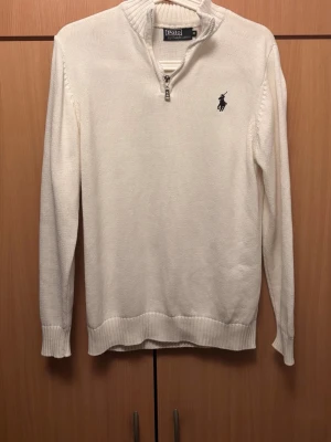 Vit halvzip-tröja från Polo Ralph Lauren - En riktigt snygg vit tröja med halv dragkedja från Polo Ralph Lauren. Tröjan har lång ärm. Perfekt för alla väder.