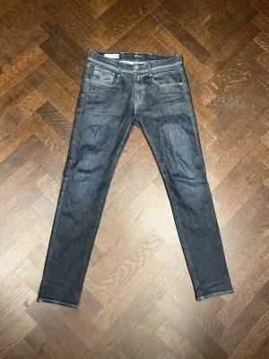 Mörkblå Replay Anbass - Snygga mörkblå slim jeans från replay med kontrastsömmar på bakfickorna. Jeansen har låg midja och är tillverkade i stretchig bomullsdenim för en bekväm passform. Passar 180 cm o nypris 1600 kr