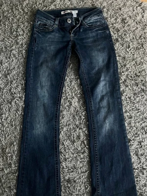 Lågmidjade bootcut jeans  - Midjemått: 36 cm Innerbenslängd: 80 cm storlek 26/32