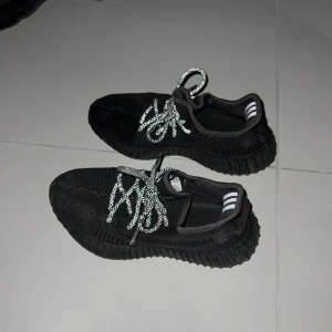 Svarta yeezys  - helt svarta yeezys sko snörena lyser i mörker dom e äkta 9/10 skick storlek 36 köptes för 7000.