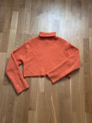 Orange ribbad cropped polotröja - Trendig orange stickad cropped polotröja med ribbad struktur och långa ärmar. Perfekt för lager på lager och ger en cool vibe till din outfit. Materialet känns mjukt och stretchigt, vilket gör den bekväm att bära hela dagen. 💕💕
