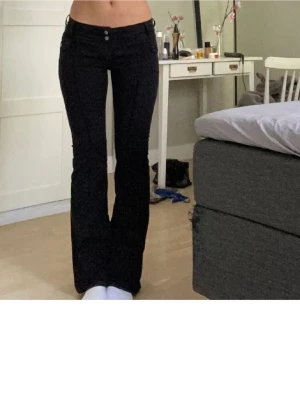 Svarta bootcut jeans med låg midja - Snygga svarta bootcut jeans med låg midja och två knappar framtill.Väldigt snygga! Dock har de gått upp på båda sidor vid skärpremmarna, men superfina endå och det går säkert att sy igen, men jag har bara inte orkat! ❤️ Köpta från plick för 450 kr, (Obs! Inte mina bilder)