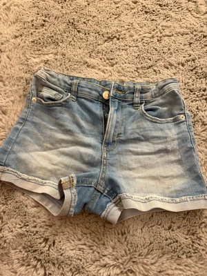 Ljusblå jeansshorts  - Ljusblå jeansshorts från LAB industries i storlek 146. ”Slitningar” på vissa ställen, inte av användning utan köpta så. Använda men inga större tecken på det. Stretchigt material.
