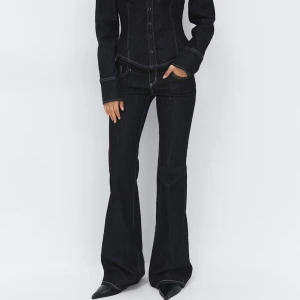 Mörkblå bootcut jeans med kontrastsömmar - Snygga mörkblå bootcut jeans med kontrastsömmar och klassisk femficksdesign. Jeansen har en markerad midja och långa ben som ger en tidlös siluett. Perfekta för dig som vill ha en stilren och trendig look.