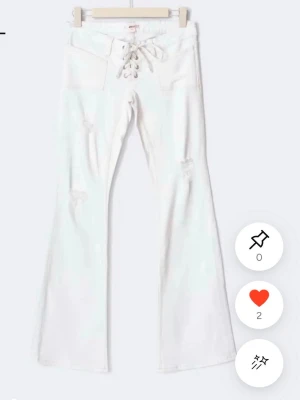 SÖKER!!!Vita bootcut jeans med snörning - SÖKER i storlek S/M!!! Snygga vita bootcut jeans med snörning i midjan och slitna detaljer på benen. 