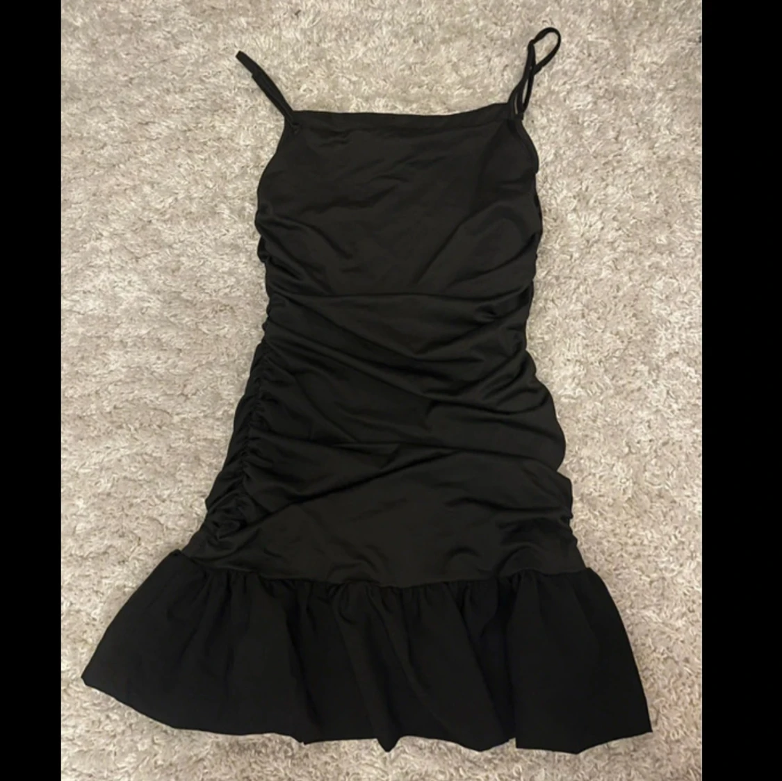 Svart kort klänning med volang