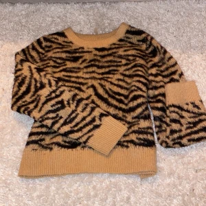 Beige stickad zebramönstrad tröja H&M - Säljer stickad tröja från H&M med svart zebramönster.  snygg och bekväm