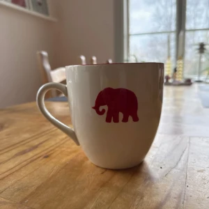 Vit stor XL kopp med två söta röda elefanter på vadere sida - Så fin kopp från indiska, perfekt om man vill avsluta kvällen på topp med en stor kopp te eller chokladmjölk. Är beroende att köpa hem nya muggar och porslin, däeför helt ny, vi rensar för utrymme i skåpet. 