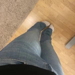 Ljusblå bootcut jeans - Säljer ett par ljusblå jeans med bootcut passform och klassisk femficksdesign. Jeansen har normal midja och är tillverkade i mjukt denimtyg som ger en avslappnad vibe. Perfekta för dig som gillar en retroinspirerad look med lite utsvängda ben. Jag är ca 162 cm lång