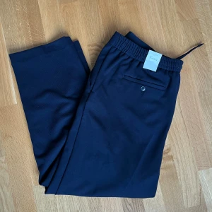 Kostymbyxor  - Kostymbyxor, helt nya med prislapp kvar! Byxorna är inte i det ”klassiska” konstumbyxematerialet utan mer som mjukisbyxor!