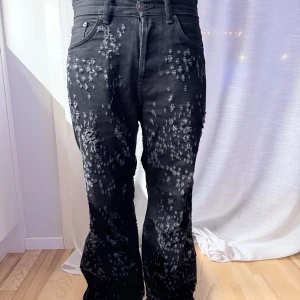 Svarta jeans från Acne Studios - Unika svarta jeans från Acne Studios med distressed detaljer över hela byxan. Storlek 28/32