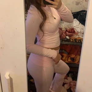 Två långärmade croppade träningströjor - Säljer två snygga långärmade croppade träningströjor i stretchigt material från Shein ((perfekt för vintern/hösten dem är otroligt varma)). En är ljusrosa och den andra är marinblå. Perfekta för gymmet eller sport, sitter tight och framhäver figuren. Passar dig som gillar stilrena och bekväma träningskläder.