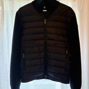 Svart pufferjacka från Moncler - Säljer sonens cardigan från Moncler då han vuxit ur den. Detta är stl M och färgen är svart. Jättefint skick! 9/10. Endast använd några få tillfällen. Nypris ca 9000kr. Inköpt på NK, (kvitto finns och kommer med köp). 