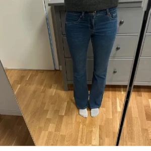 Blå bootcut jeans från HM, stl 36 - Säljer ett par snygga blå jeans från HM Divided i klassisk bootcut-modell. Jeansen har låg midja, fem fickor och är tillverkade i mjukt bomullsmaterial med lite stretch. 