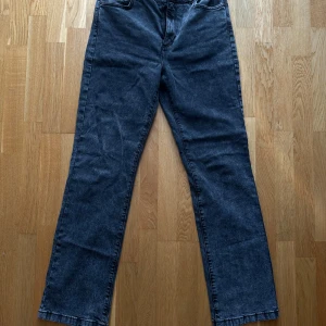 Grå straight jeans från Carin Wester EU 42 - Snygga grå jeans från Carin Wester med klassisk femficksdesign och raka ben. Jeansen har en mörk tvätt och detaljer som dragkedja och knapp i midjan. Passar dig som gillar en enkel och clean look med lite vintagekänsla. Sytt ihop för att få ihop midjan, går att ta bort enkelt 