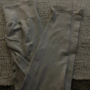 Gråa seamless leggings - Snygga grå leggings med ribbade detaljer och hög midja. De är sömlösa och har en tight passform som sitter skönt mot kroppen. Perfekta för träning eller chill dagar. Scrunch där bak
