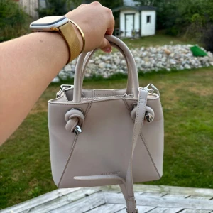 Beige handväska  - Super snygg och stilren  handväska från Art Street med knutdetaljer på handtagen. Perfekt storlek, får plats med mycket! Endast använd en gång då jag har fler många liknande🙌 Nysick