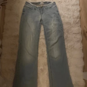 Ljusblå jeans från Nelly, storlek 32 - Säljer ett par ljusblå jeans från Nelly i klassisk femficksmodell. Jeansen har raka ben och normal passform, med snyggt slitna detaljer och dragkedja i gylfen. Perfekta för dig som gillar en avslappnad stil.