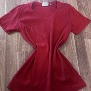 Röd t-shirt från Jackpot Daily - Röd t-shirt från Jackpot Daily i 100% ekologisk bomull. Klassisk rund halsringning och korta ärmar. Enkel och stilren modell som passar perfekt till jeans eller shorts.