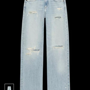 Ljusa blå jeans med slitningar - Snygga ljusblå jeans med slitna detaljer och hål på både fram- och baksidan. Modellen har raka ben och klassisk femficksdesign. Säljer pågrund av att de ej kommer till användning för mig tyvärr!