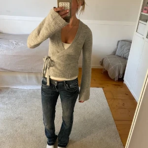 Omlottkofta  - Stickad grå wrap cardigan ifrån Gina Tricot i storlek xs, litet hål vid lappen men märks inte av