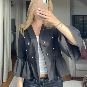 Svart kavaj med pärlor - Snygg svart kavaj med pärldetaljer framtill och volanger. Köpt secondhand, vet tyvärr inte märke✨ 
