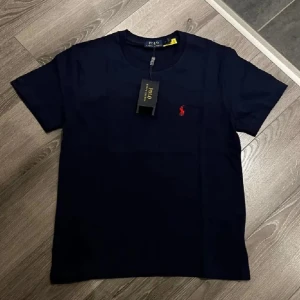 Polo Ralph Lauren T-shirt Marinblå - Säljer en helt ny marinblå Polo Ralph Lauren T-shirt med hög kvalite för väldigt bra pris. Den är helt ny med prislapp och oanvänd. Det står L på tröjan som storlek men passar som S/M. Skriv vid intresse! 