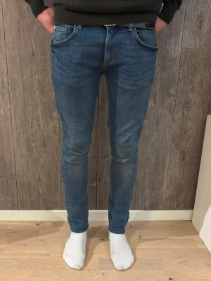 Tiger of Sweden – Slim Fit Jeans Blue Denim (W30 L32) - Snygga blå jeans från Tiger of Sweden i slim fit-passform.  ✔️ Storlek: W30 L32 (39cm 97cm) ✔️ Modell: Slim Fit ✔️ Färg: Blå denim ✔️ Skick: Bra skick, inga hål eller fläckar