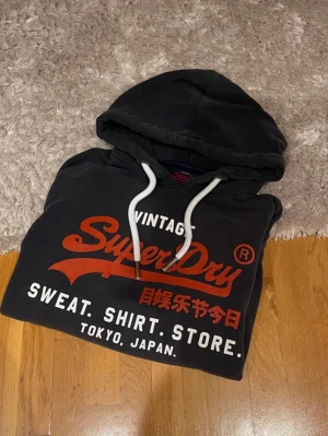 Svart Superdry Hoodie - Hej! Säljer en svart Superdry hoodie i storlek L. Bra skick. Hör av er vid frågor