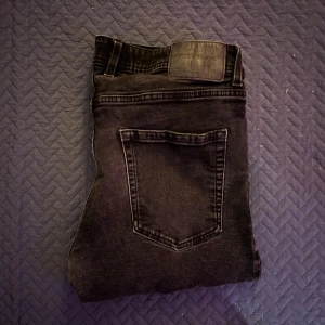 Svarta skinny jeans från Crocker - Säljer ett par svarta jeans från Crocker med klassisk femficksdesign och skinny passform. Jeansen har en mörk tvätt, smal siluett och är tillverkade i stretchigt denim för extra komfort. Perfekt för dig som gillar en tajt look och vill ha jeans som sitter snyggt hela dagen.