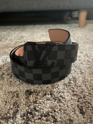 Svart L-V bälte - Snyggt svart rutigt bälte som passar väldigt bra till många outfits, snabb leverans. Fraktar inom 24h