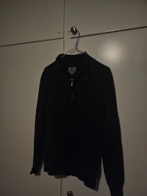 Svart stickad half zip-tröja Crocker - Svart stickad tröja från Crocker i storlek XS med ribbad krage och half zip-dragkedja framtill. Perfekt för dig som gillar en enkel men snygg look. Långärmad och mjuk i materialet, passar till många olika outfits. Priset kan dras ner till 110 kr.