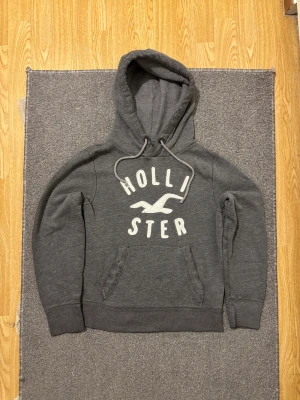 Grå Vintage Hollister Hoodie - Säljer denna as snygga och sällsynta Hollister hoodien | Skicket är perfekt | Storlek S | Modell 175cm , väger 68kg och passar mig fint, se sista bild | För eventuella frågor & funderingar hör av dig! | Pris diskuterbar |