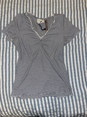 Randig v-ringad topp Holly Whyte - Vit och marinblå randig topp från Holly Whyte by Lindex i storlek S. Toppen har v-ringning med spetskant, korta ärmar och lätt rynk vid bysten💕