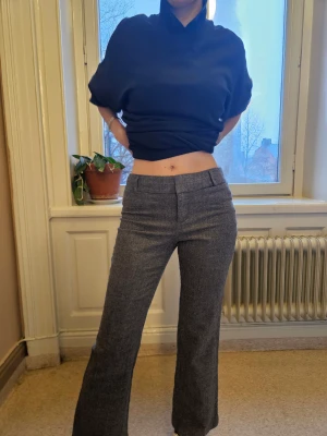Grå low-waisted kostymbyxor - Snygga grå kostymbyxor med lite boot-cut. De är low-waist och är 100% äkta ylle. Fina detaljer både fram och bak. Pris kanske går att pruta ner lite vid snabb affär.