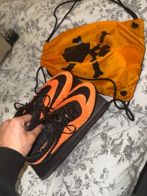 Nike Hypervenom Phantom RGN SE FG – EU 42 – Jätte bra skick – Box & påse ingår - Säljer ett par Nike Hypervenom Phantom RGN SE FG i den ikoniska orange/svarta färgen. Skorna är i väldigt fint skick och sparsamt använda – se bilder för egen bedömning.  Modell: Nike Hypervenom Phantom RGN SE FG Storlek: EU 42 (US 8.5 / UK 7.5 / 26.5 cm) Underlag: FG – naturgräs Skick: Mycket bra Originalkartong + Nike Hypervenom-påse ingår  Hypervenom-serien är känd för sin fantastiska touch, tajta passform och explosiva känsla, perfekt för snabba och offensiva spelare. RGN SE-versionen är des