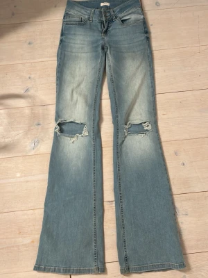 Ljusblå bootcut jeans från Nelly - Säljer ett par snygga ljusblå bootcut jeans från Nelly med slitningar/hål på knäna💕(ord pris 699) 