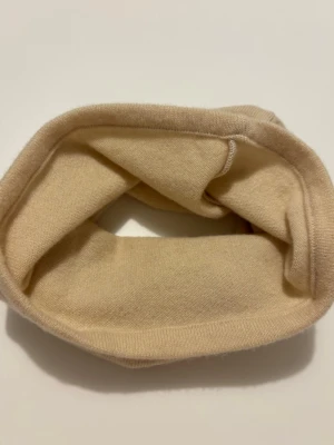 Ljusgul kashmir buff - Mjuk och enkel gul halsvärmare i 100% kashmir. Perfekt att dra över huvudet för extra värme under kyliga dagar. Stilren design utan mönster eller detaljer, passar till det mesta.