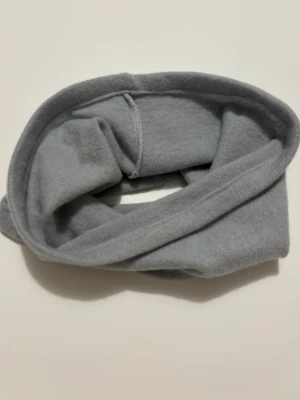 Ljusblå kashmir buff - En enkel och stilren ljusblå kashmir buff utan mönster eller detaljer.  Perfekt att dra över en tröja för extra värme under kyliga dagar. 100% kashmir