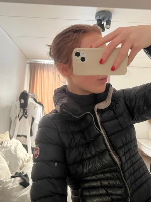 Svart pufferjacka från Colmar - Säljer en svart pufferjacka från Colmar med klassisk logga på ärmen. Jackan har hög krage, quiltad design och dragkedja framtill. Perfekt för kyliga dagar och riktigt snygg till jeans eller träningsbyxor.