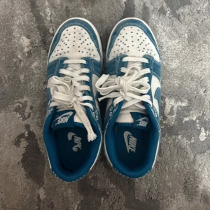 Nike Dunk Low blå och vita sneakers - Säljer dessa Nike Dunk Low sneakers i blått och vit.Skorna är ganska bekväma😍passar inte mig längre. 
