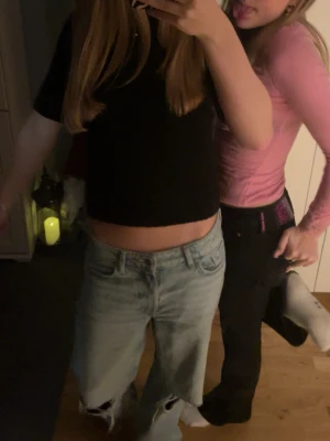 Ljusblå baggy jeans med hål på knäna - Säljer ett par ljusblå baggy jeans med slitna hål på båda knäna. Jeansen har klassisk femficksmodell, raka ben och låg midja. Perfekta för en avslappnad och trendig look.